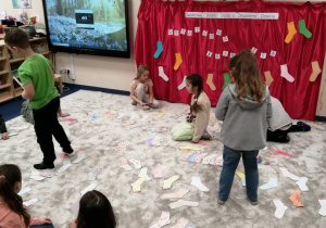 Dzieci układają kolorowe skarpetki na dywanie